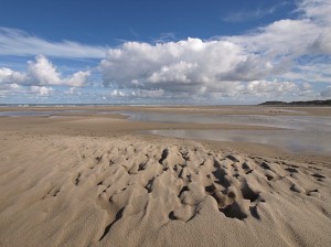 strand met zandstructuur en wolkenlucht